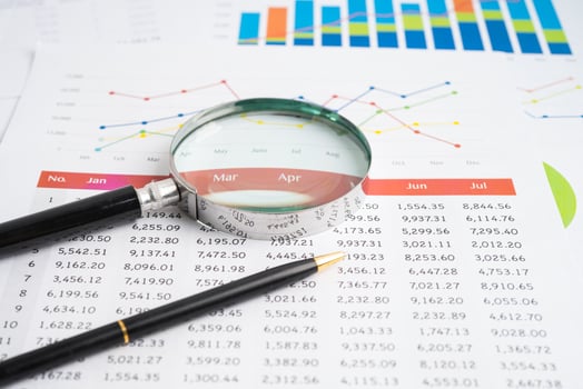 Magnifying glass on spreadsheet and graph paper. Financial development, Banking Account, Statistic, Investment Analytic research data economy, Business. photo