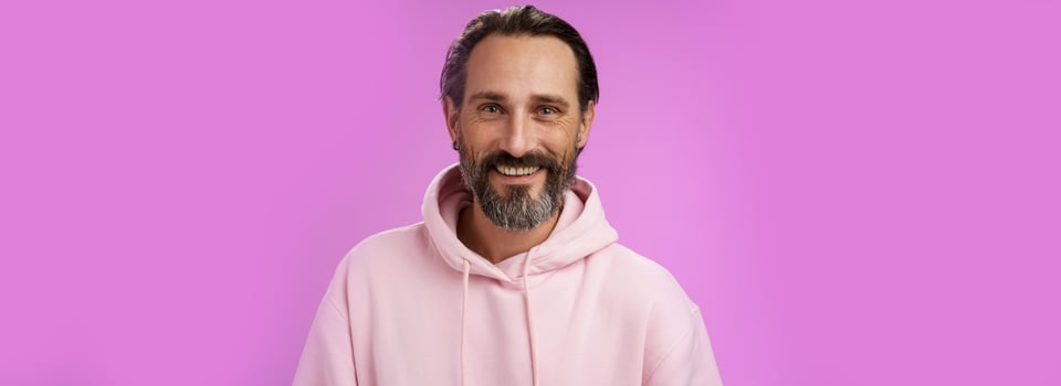 Waist-up happy cheerful caucasian bearded man grey hair in pink trendy hoodie smiling broadly feel healthy attend gym lead active lifestyle grinning white perfect teeth, standing purple background photo