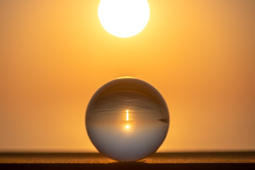 Round glass ball, in the ball sunset on the sea, concept summer, vacation, travel, vacation by the sea photo