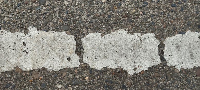 a close up of a road with white paint on it photo