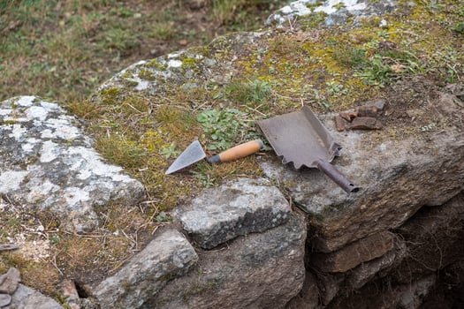 Tools of an archaeologist on a wall in an archaeological excavation, trowel and small shovel. photo