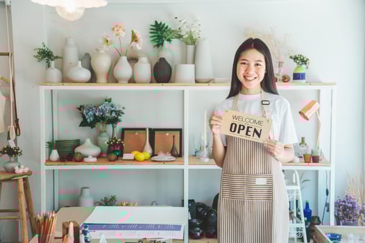 Smiling online small business owner holding a sign saying Open and happily working at a courier business offering orders and products to customers.Online retailer - online shopping. photo