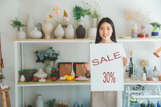 online Smilingmall business owner holding a sign saying sale and happily working at a courier business offering orders photo