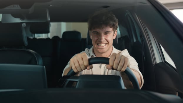Happy Caucasian man driving new luxury electric crossover car in automobile salon dealership rejoice buy celebrate sitting inside cab auto transport credit loan emotions of happiness buyer achieve photo