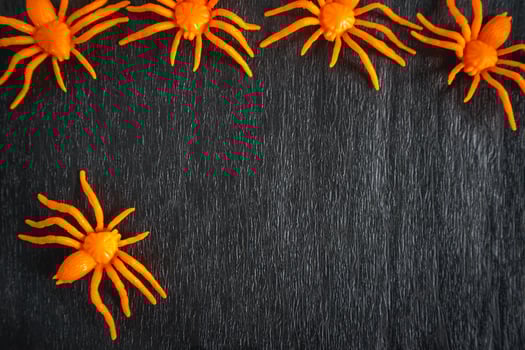 Fake orange spiders on a black background. Nice Background for halloween for posters or flyers. photo