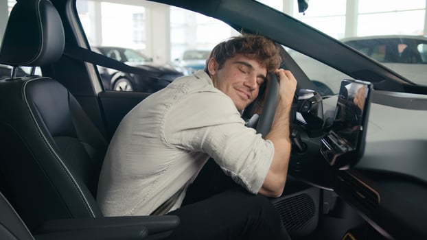 Caucasian client man buyer guy customer male sitting in luxury new car choosing auto visit showroom choose automobile rent test drive buying enjoy vehicle choice embrace hug cuddling wheel steering photo