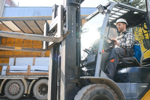Portrait of heavy industry forklift driver giving thumbs up and smiling photo