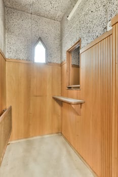 A room with a wooden paneled wall and a window photo