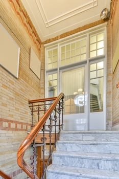 A stairway with a handrail and a sign on the wall photo