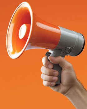 A person grips an orange megaphone, ready to make an important announcement against a striking backdrop photo