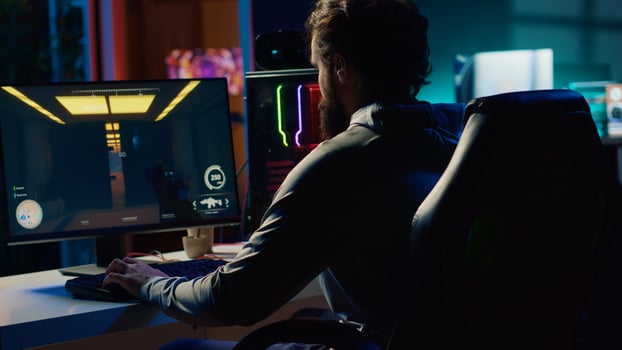 Man sitting on gaming chair, playing first person shooter videogame with gun shooting laser bullets. Gamer arriving home, ready to start game with dark atmospheric industrial setting photo