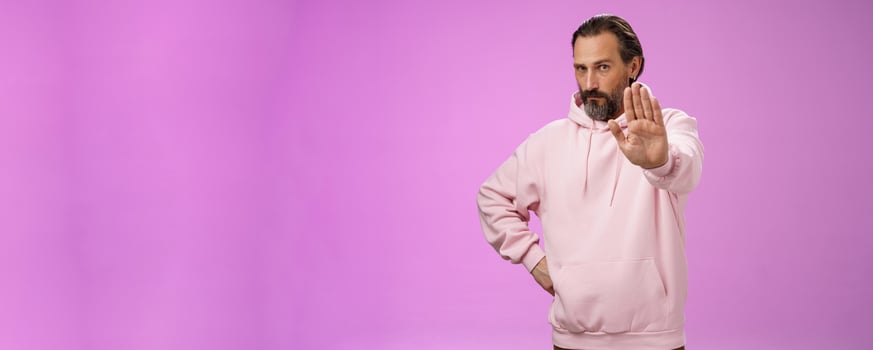 Stand right there. Portrait serious-looking bossy adult bearded father extend arm stop taboo no gesture forbidding come party look solid confident demanding quit, standing purple background photo