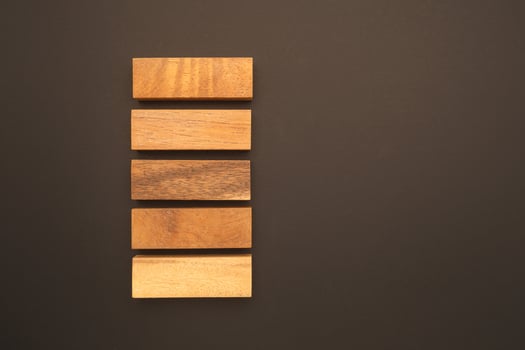 Top view of five empty wooden blocks isolated on a black background. Space for text photo