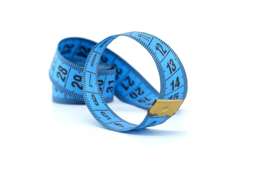 Close-up of a blue measuring tape rolled up on a white background photo