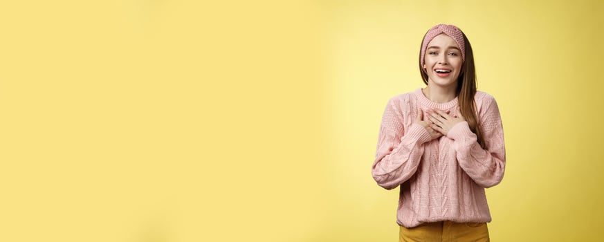Grateful delighted charming young 20s woman wearing sweater pressing arms to chest happily, thankful, expressing gratitude, heartfelt appreciating gesture smiling amused, in love with romantic gift photo