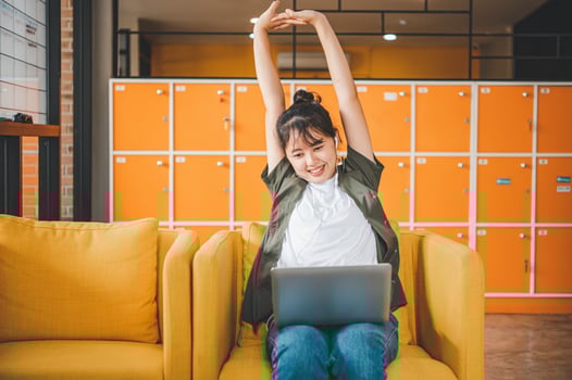 Young Asian freelancers are stretching oneself and relaxing after working and planning to work while working on laptop in the cafe photo