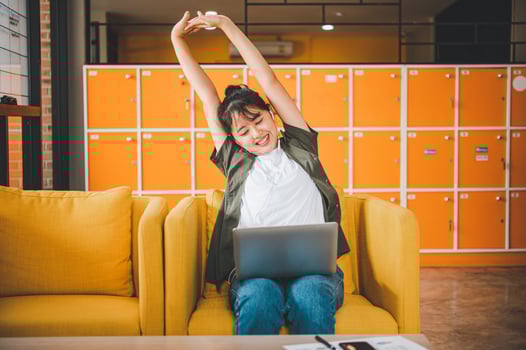 Young Asian freelancers are stretching oneself and relaxing after working and planning to work while working on laptop in the cafe photo