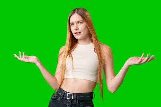 Young Woman Gesturing With Both Hands Against A Green Screen photo