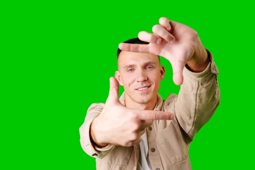Young Man Posing With Hand Gesture Against Bright Green Background photo