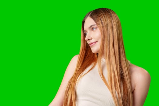Woman Wearing Black Jeans and a Purple Top Posing in Front of a Green Screen photo