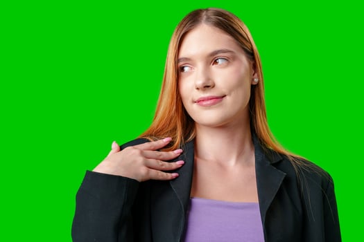 Young Woman Wearing Black Blazer and Purple Top Against Green Screen photo