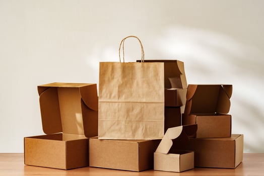 Brown Paper Bag and Cardboard Boxes on a Wooden Surface photo