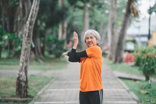 white-haired elderly person exercising in the park early in the morning. photo