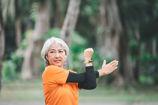 white-haired elderly person exercising in the park early in the morning. photo