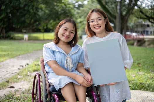 Young Disabled Woman and Best Friend Painting Together in a Garden on a Sunny Day photo