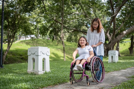 Young Disabled Woman in a Wheelchair Enjoying a Relaxing Day in the Park with Her Best Friend photo