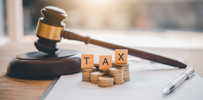 Tax law concept. Wooden blocks word TAX on coin stack .with gavel and money on the table. photo