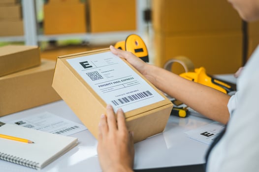 startup young female small business owners attaching shipping labels to cardboard boxes or parcels for delivery of customer orders-concept shopping online photo