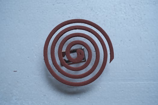 A close-up shot of a brown mosquito coil on a white background. photo