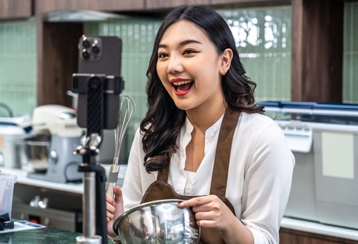 Young asian women is shop owner Put on an apron making cream for cupcakes, Using electric mixer, Preparing Cookies, Cooking, Homemade, Made specifically to sell, and recording for food blog photo