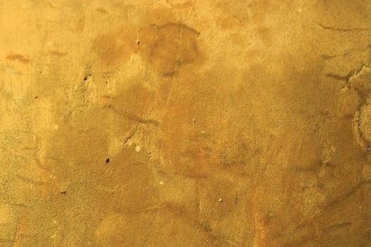Rough, textured golden surface with subtle variations. photo