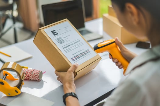 online small business owner scans a barcode-labeled parcel with a barcode scanner to verify a customer's order before it is delivered to the customer. photo