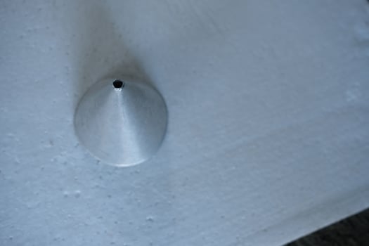 Close-up of a metal cone on a white surface. photo