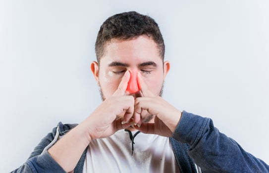 Sore person suffering with nasal bridge on isolated background. Suffering man with nasal congestion photo