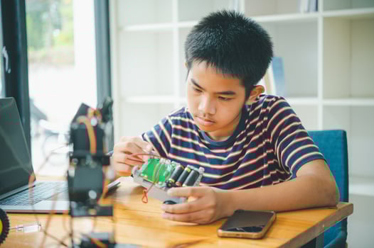Asian boy learning and studying the work of technology robots.homeschool and science for tech project. playing childhood kids hobby leisure lifestyle people toys robotics technology. photo