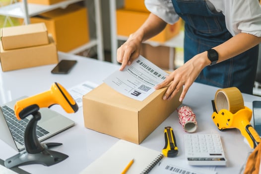 startup young female small business owners attaching shipping labels to cardboard boxes or parcels for delivery of customer orders-concept shopping online photo