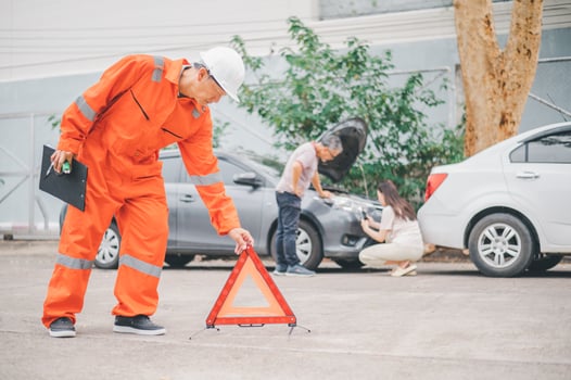 Insurance officers hold a red emergency triangle sign on the road to indicate that there is an accident or car breakdown on the road ahead. photo