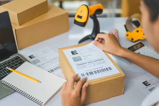 startup young female small business owners attaching shipping labels to cardboard boxes or parcels for delivery of customer orders-concept shopping online photo