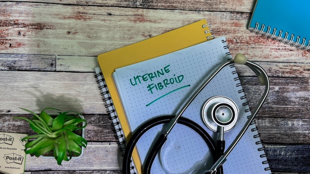 Concept of Uterine Fibroid write on book isolated on Wooden Table. photo