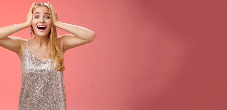 Amazed excited nervous young beautiful blond woman in silver stylish dress cannot believe own luck happiness hold hands head smiling screaming astonished positive awesome news, triumphing photo