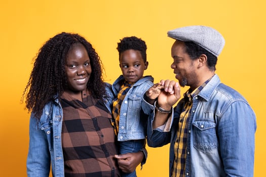 African american happy family posing together on camera, smiling couple embracing their small baby boy. Cheerful young mom and dad showing affection to their toddler in studio. photo