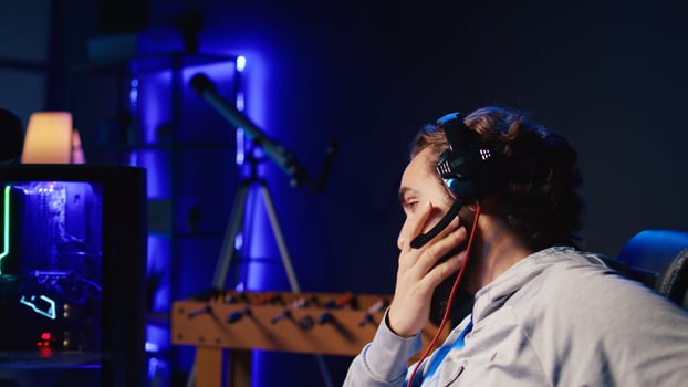Upset gamer frustrated after losing online competitive multiplayer match playing on cutting edge gaming setup. Man feeling sad after being defeated in science fiction flying videogame photo