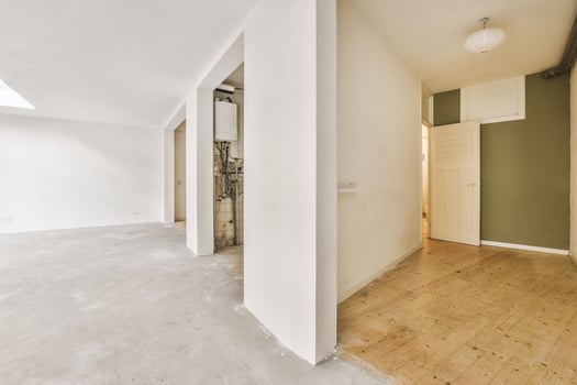 An empty room with a wooden floor and a green door photo