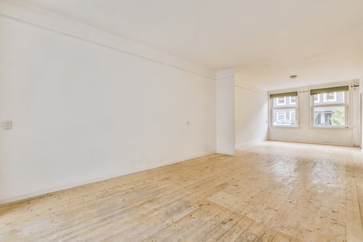 An empty room with wooden floors and white walls photo