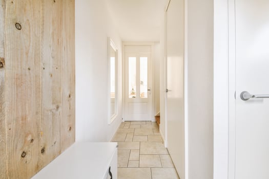 A hallway with a wooden wall and a white door photo