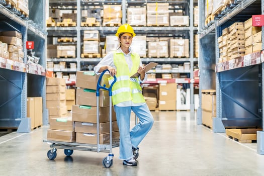 Employee female warehouse worker in uniform working in inventory with stacked up shelves in logistics center factory, woman is checking a customer order to prepare the goods for delivery. photo